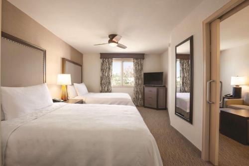 土桑土桑圣菲广场大学希尔顿惠庭套房酒店的酒店客房设有两张床和电视。