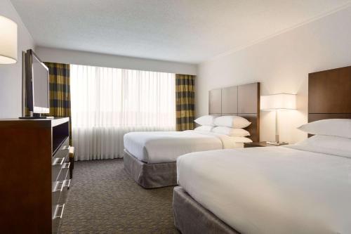 林夕昆高地Embassy Suites by Hilton Baltimore at BWI Airport的酒店客房设有两张床和一台平面电视。