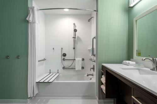 夏洛特夏洛特大学研究园希尔顿欣庭2号套房酒店的浴室配有浴缸、淋浴和水槽