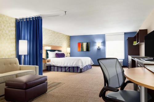 圣安吉洛圣安吉洛希尔顿欣庭套房酒店的酒店客房带一张床、一张桌子和椅子