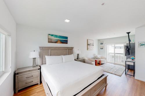 马拉松Mermaid's Retreat的卧室配有一张白色大床和一张书桌
