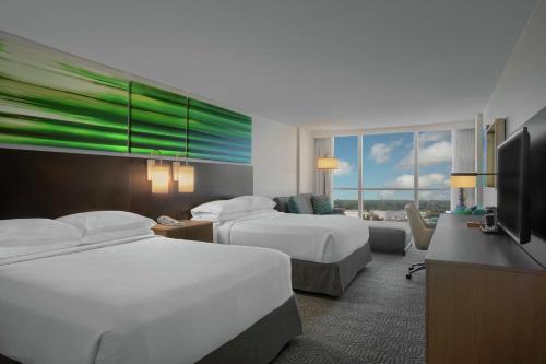 奥兰多希尔顿逸林酒店 - 奥兰多环球影城入口的酒店客房设有两张床和一台平面电视。