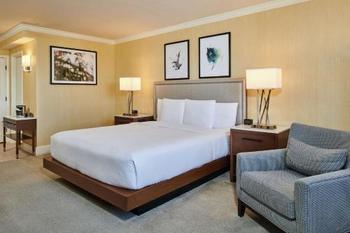 盐湖城盐湖城机场希尔顿逸林酒店的配有一张床和一把椅子的酒店客房