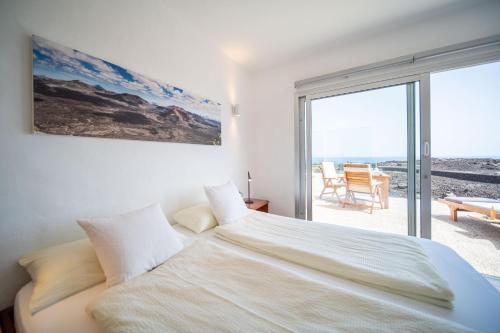 MalaStudio La Baja的白色卧室设有一张大床和一个阳台