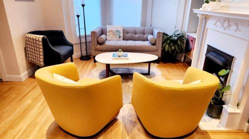 旧金山Sunny Victorian with Stunning View and Wraparound Deck的客厅配有2把黄色椅子和桌子