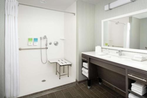 夏洛茨维尔Home2 Suites By Hilton Charlottesville Downtown的浴室配有盥洗盆和带镜子的淋浴