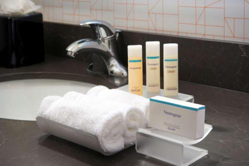 迈阿密迈阿密市区/布里克尔希尔顿惠庭套房酒店的浴室盥洗盆、毛巾和牙刷,位于柜台上