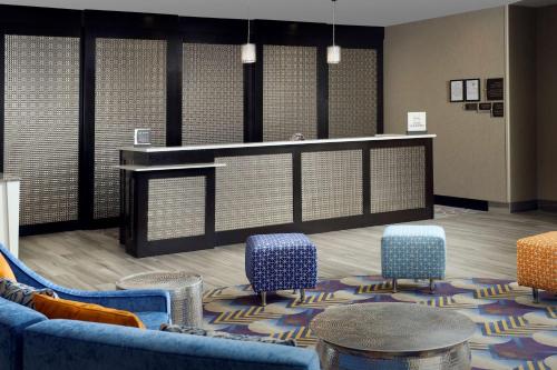 梅泰里Homewood Suites by Hilton Metairie New Orleans的一间设有蓝色椅子和柜台的等候室