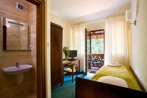 波兰尼卡-兹德鲁伊薇拉扎梅泽科酒店的一间带床和水槽的浴室以及一张书桌