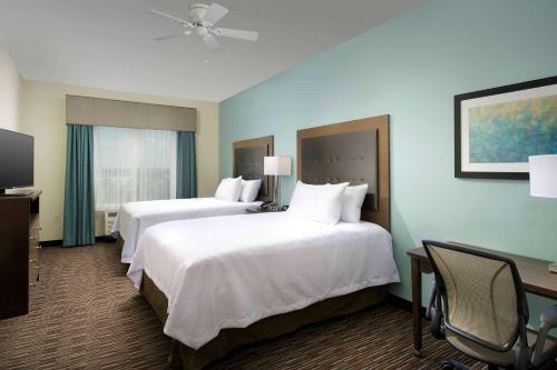 圣安东尼奥圣安东尼奥机场希尔顿惠庭套房酒店的酒店客房配有两张床和一张书桌