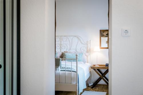 PählSeenswert - Vegane Pension und Ferienwohnungen am Ammersee的卧室配有白色的床和桌子