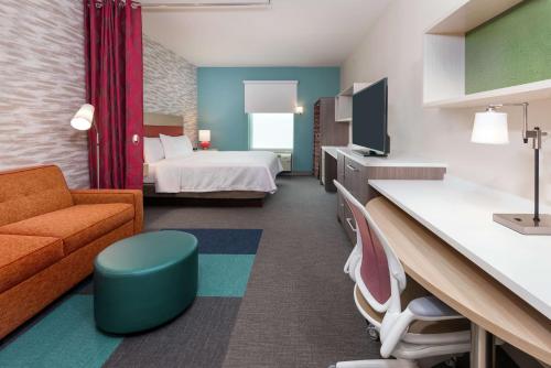 奥兰多Home2 Suites By Hilton Orlando Near UCF的酒店客房,配有床和沙发