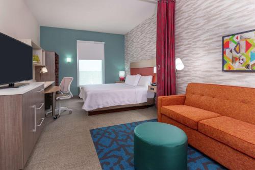 奥兰多Home2 Suites By Hilton Orlando Near Universal的酒店客房,配有床和沙发