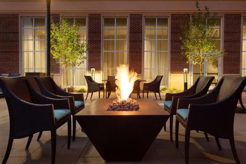 夏洛特Homewood Suites By Hilton Charlotte Southpark的庭院内的一个火坑,庭院里设有椅子和一座建筑