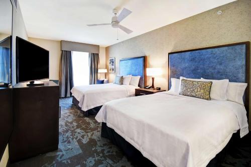 盐湖城Homewood Suites By Hilton Salt Lake City Airport的酒店客房设有两张床和一台平面电视。