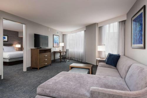渥太华Homewood Suites By Hilton Ottawa Downtown的酒店客房设有一张沙发和一张床