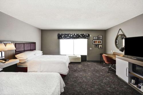 哥伦布哥伦布伊斯顿区汉普顿套房旅馆的酒店客房设有两张床、一张书桌和一个窗户。
