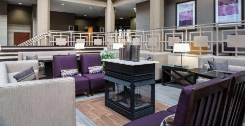 迪尔菲尔德Embassy Suites by Hilton Chicago North Shore Deerfield的大堂设有紫色椅子和钢琴