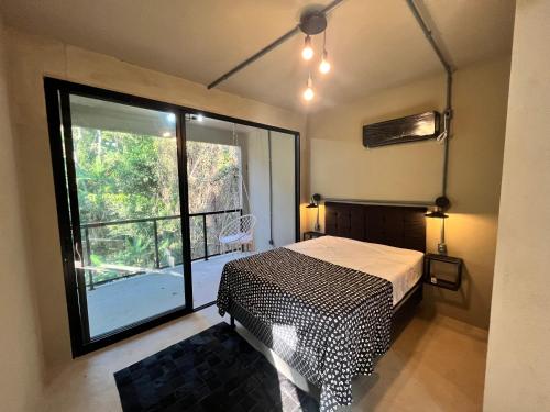 里约热内卢Monkey Lodge - Casa na Mata的一间卧室设有一张床和一个大窗户