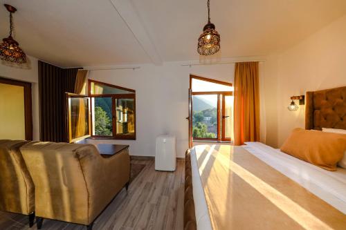 佩奇Chalet Kujta的一间卧室配有一张床、一张沙发和窗户。