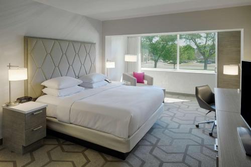 布卢姆菲尔德山The Kingsley Bloomfield Hills - a DoubleTree by Hilton的卧室设有一张白色大床和一扇窗户。