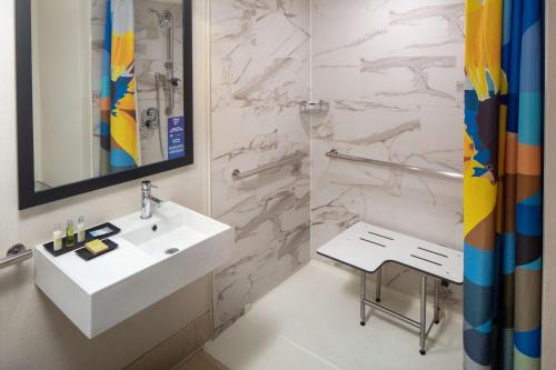 贝塞斯达The Bethesdan Hotel, Tapestry Collection by Hilton的浴室配有白色水槽和淋浴。