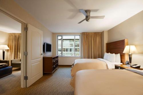 巴尔的摩巴尔的摩希尔顿惠庭套房酒店的酒店客房设有两张床和电视。
