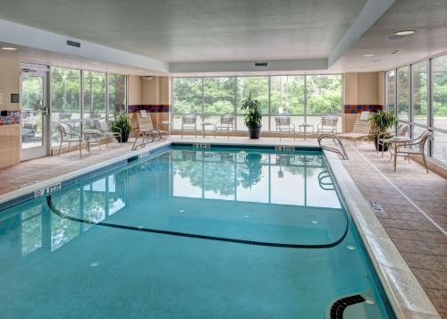 韦斯特福德韦斯特福德-切姆斯福德汉普顿套房酒店的一座配有桌椅的酒店游泳池