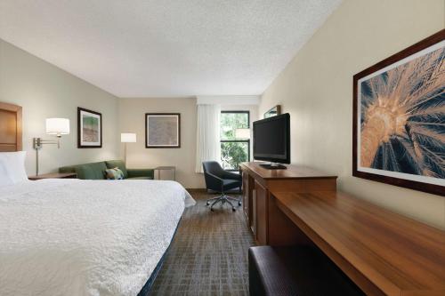 奥兰多奥兰多会议中心国际大道区汉普顿酒店的酒店客房配有一张床和一张书桌及一台电视