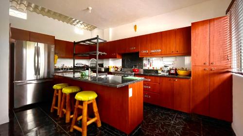 蒙塔尼塔Hostal Laurita Beach的厨房配有木制橱柜和黄色凳子