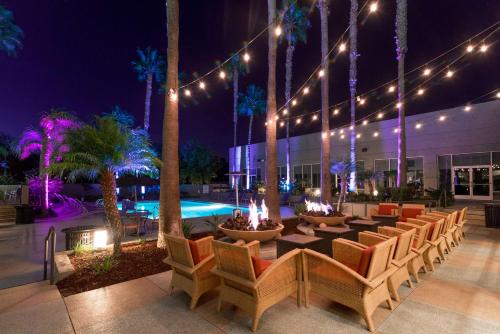 圣地亚哥圣地亚哥迷踪谷希尔顿逸林酒店的一个带桌椅的庭院和一个夜间游泳池