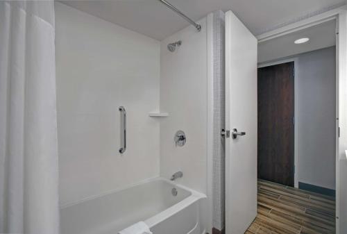 索尔兹伯里索尔兹伯里汉普顿酒店的白色的浴室设有浴缸和淋浴。