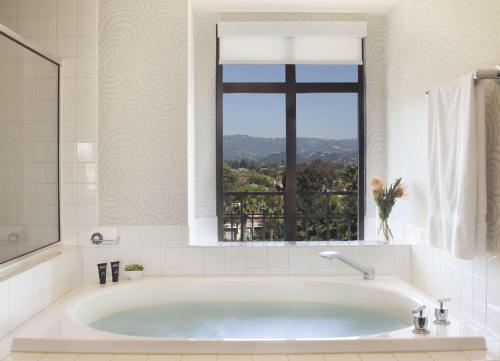 库比蒂诺库比蒂诺朱尼伯古玩收藏希尔顿酒店的带浴缸的浴室和窗户