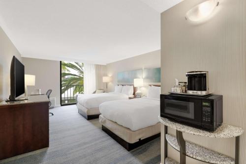 尔湾欧文/橙县机场希尔顿酒店的酒店客房设有两张床和电视。