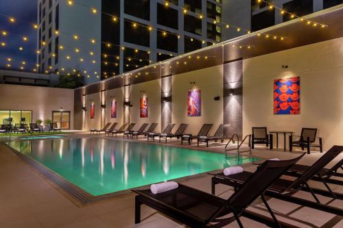 奥斯汀奥斯汀希尔顿酒店的一座带椅子的游泳池以及一座建筑