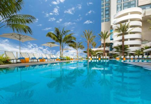 圣地亚哥圣地亚哥海湾希尔顿酒店的一座棕榈树游泳池和一座建筑