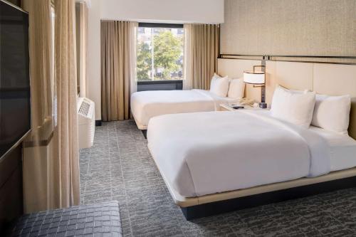 泽西市泽西市希尔顿双树套房酒店的酒店客房设有两张床和窗户。
