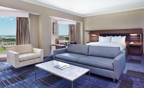 伊丽莎白希尔顿纽华克机场酒店的酒店客房配有床、沙发和桌子。