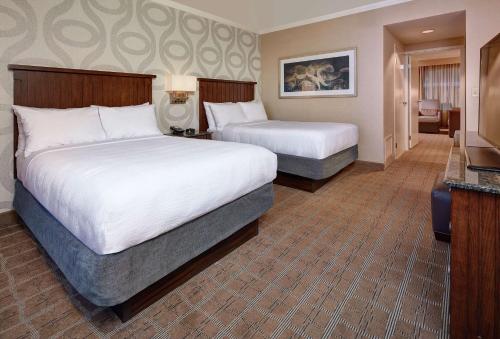 圣地亚哥Embassy Suites by Hilton San Diego La Jolla的酒店客房设有两张床和电视。