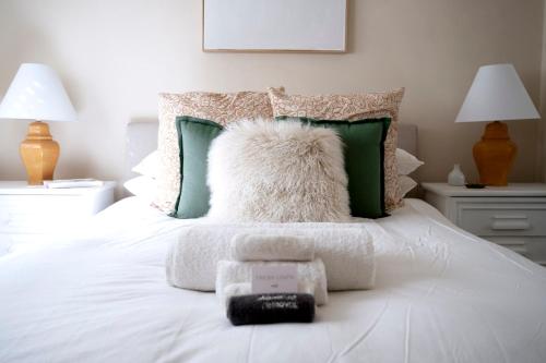 达博Popular Central Location I NEW LINEN I Gated Estate I STAY DUBBO的一张带白色枕头和绿色枕头的床