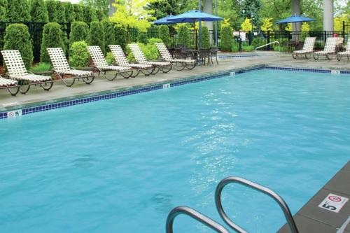 斯波坎斯波坎市中心希尔顿逸林酒店的一个带椅子和遮阳伞的大型游泳池