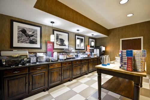 博兹曼博兹曼汉姆普顿酒店的厨房配有木制橱柜和食品柜台。