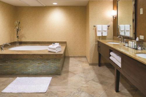 西塔科西雅图机场希尔顿逸林酒店的带浴缸和两个盥洗盆的大浴室