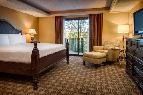 西塔科西雅图机场希尔顿逸林酒店的一间卧室配有一张床、一把椅子和电视