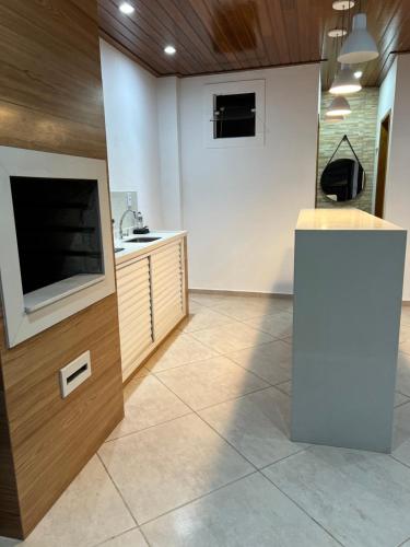 帕萨夸特鲁Hostel Passa4的一个带水槽的厨房和客房内的电视