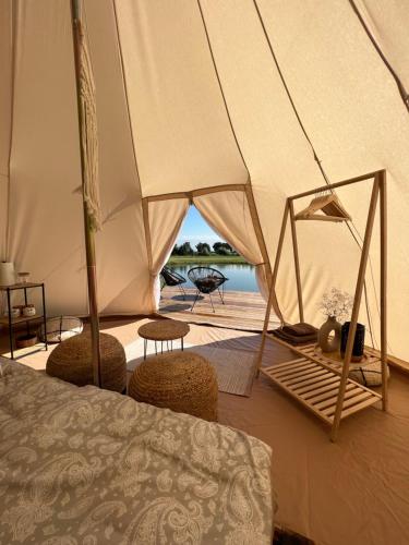 鲁斯内Glamping Rusne的一间卧室配有带椅子和桌子的帐篷