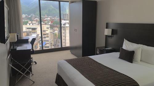 加拉加斯HOTEL CHACAO SUITES的酒店客房设有一张床和一个大窗户