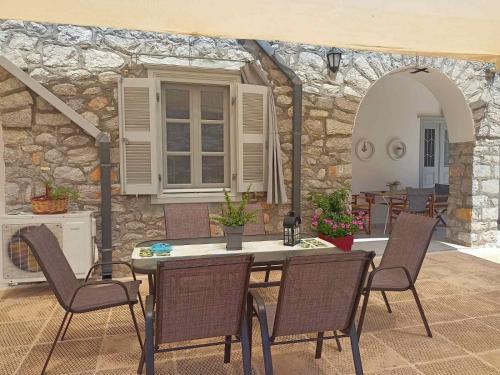 伊兹拉Smaragdas Paradise的一个带桌椅和石墙的庭院