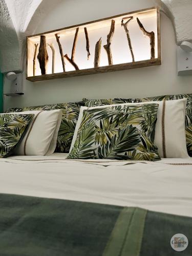 法萨诺Calamedde Guest House nel Centro Storico Pugliese的一张带枕头的床和墙上的镜子