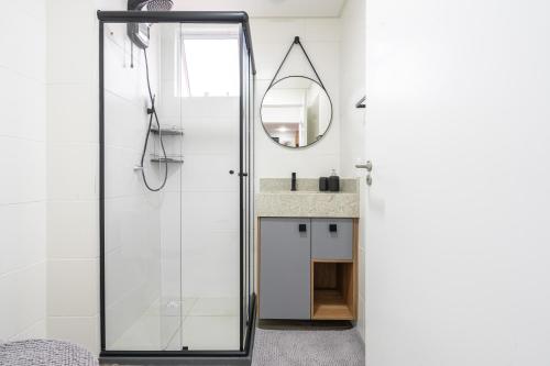皮萨拉斯Apartamento 150m da PRAIA com SACADA, WI-FI AR CONDICIONADO, PISCINA, PORTARIA 24h, PLAYGROUND e vaga de GARAGEM的设有带镜子和水槽的淋浴的浴室